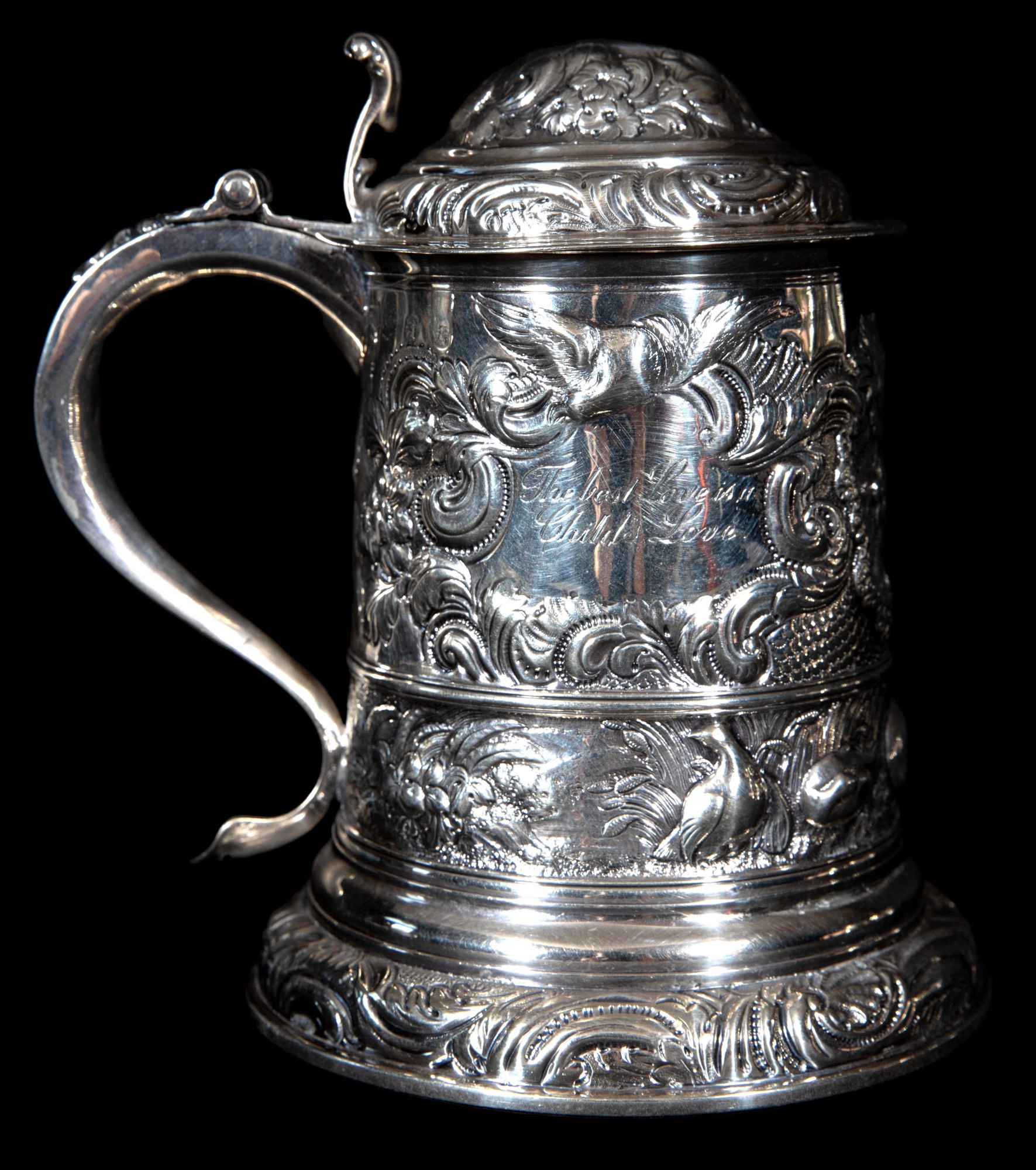 Tankard em prata Inglesa do período Georgeano repuxada e cinzelada ornamentado com volutas, folhagens e florões -